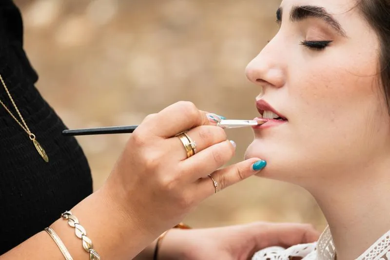 מריחת אודם לאשה עוצמת עיניים