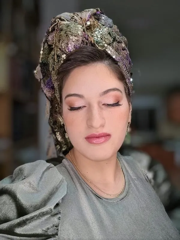 פנים של אשה מאופרת עם מטפחת מצטלמת