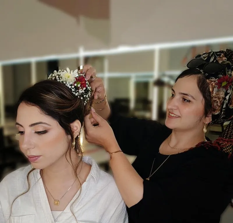 רבקה רחמים קושרת סיכת פרח לשיער של כלה